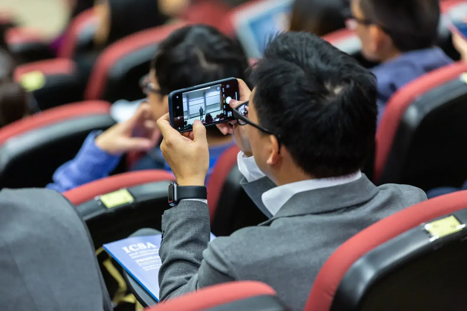 Speaker addressing an audience with a handheld microphone